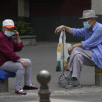 
              Elderly residents wearing mask chat on as street on Monday, May 23, 2022, in Beijing. (AP Photo/Ng Han Guan)
            