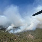 
              In this photo provided by the New Mexico National Guard, a New Mexico National Guard Aviation UH-60 Black Hawk flies as part of firefighting efforts, dropping thousands of gallons of water with Bambi buckets from the air on the Calf Canyon/Hermits Peak fire in northern New Mexico on Sunday, May, 1, 2022. Thousands of firefighters are battling destructive wildfires in the Southwest as more residents are preparing to evacuate.  (New Mexico National Guard via AP)
            