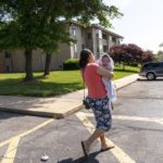 
              Yury Navas, 29, of Laurel, Md., walks through her apartment complex to the grocery store where she hopes to find more formula, while holding her two-month-old baby Ismael Galvaz, in Laurel, Md., Monday, May 23, 2022. After this day's feedings she will be down to their last 12.5 ounce container of formula. Navas doesn't know why her breastmilk didn't come in for her third baby and has tried many brands of formula before finding the one kind that he could tolerate well, which she now says is practically impossible for her to find. To stretch her last can she will sometimes give the baby the water from cooking rice to sate his hunger. The store by her home yet again had none of the only type of formula that her baby can take without digestive upset. (AP Photo/Jacquelyn Martin)
            