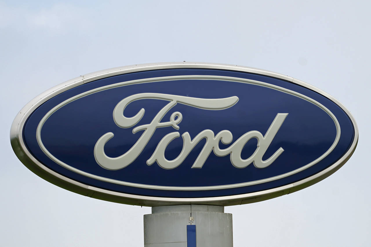 FILE - A Ford logo is seen on signage at Country Ford in Graham, N.C., Tuesday, July 27, 2021. Ford...