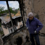 
              Anatolii Chovpin shows the damaged building where he lives ruined by attacks in Irpin, outskirts Kyiv, Ukraine, Thursday, May 26, 2022. (AP Photo/Natacha Pisarenko)
            