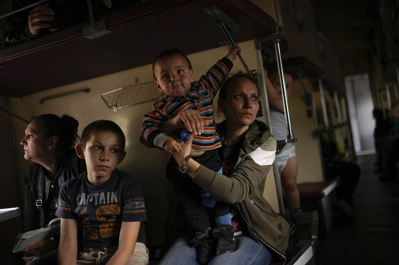 Yana Skakova and her son Yehor who fled from Lysychansk with other people sit in an evacuation trai...