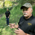 
              FILE - Dennis Parada, right, and his son Kem Parada stand at the site of the FBI's dig for Civil War-era gold in Sept, 2018, in Dents Run, Pennsylvania. A scientific report commissioned by the FBI shortly before agents went digging for buried treasure suggested that a huge quantity of gold was below the surface, according to newly released government documents. (AP Photo/Michael Rubinkam, File)
            