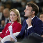 
              French president Emmanuel Macron removes his earpiece as European Parliament President Roberta Metsola looks at him, during the Conference on the Future of Europe, in Strasbourg, eastern France, Monday, May 9, 2022. Macron traveled to Strasbourg on Monday as the final report on the Conference of Europe was set to be presented by EU institutions leaders. France currently holds the six-month rotating presidency of the Council of the EU. (AP Photo/Jean-Francois Badias)
            