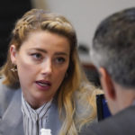 
              Actor Amber Heard speaks to her legal team in the courtroom at the Fairfax County Circuit Courthouse in Fairfax, Va., Friday, May 27, 2022. Actor Johnny Depp sued his ex-wife Amber Heard for libel in Fairfax County Circuit Court after she wrote an op-ed piece in The Washington Post in 2018 referring to herself as a "public figure representing domestic abuse." (AP Photo/Steve Helber, Pool)
            