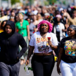 
              People march to the scene of a shooting at a supermarket in Buffalo, N.Y., Sunday, May 15, 2022. (AP Photo/Matt Rourke)
            