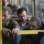 
              Ukrainian servicemen sit in a bus after they were evacuated from the besieged Mariupol's Azovstal steel plant, near a prison in Olyonivka, in territory under the government of the Donetsk People's Republic, eastern Ukraine, Tuesday, May 17, 2022. More than 260 fighters, some severely wounded, were pulled from a steel plant on Monday that is the last redoubt of Ukrainian fighters in the city and transported to two towns controlled by separatists, officials on both sides said. (AP Photo)
            