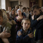 
              FILE -Parishioners line up for Holy Communion after an Orthodox religion service celebrating the Palm Sunday in a church in Moscow, Russia, Sunday, April 17, 2022. The economic consequences have yet to fully play out. In the early days of the war, the Russian ruble lost half its value. But government efforts to shore it up have actually raised its value to higher than its level before the invasion. (AP Photo, File)
            