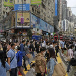 
              People walk across a street in Hong Kong, Tuesday, May 3, 2022. Hong Kong's economy shrank by 4% compared with a year earlier in the quarter ending in March after the Chinese territory shut restaurants and other businesses to fight a spike in coronavirus infections. (AP Photo/Kin Cheung)
            