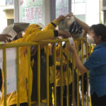 
              A supermarket employee hands over a bag of groceries to a deliveryman in Shanghai, China, Monday, May 23, 2022. Shanghai reported 480,000 people were still confined to their homes due to COVID-19 precautions, while 1.59 million were permitted to move around their neighborhoods and 21.2 million were under lighter restrictions. (AP Photo/Chen Si)
            