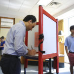 
              Mayoral candidate Craig Greenberg, left, fills out his ballot in the primary election at the Louisville Presbyterian Theological Seminary in Louisville, Ky. on Tuesday, May 17, 2022. His son Benjamin, 16, waits for him at right. (Sam Upshaw Jr./Courier Journal via AP)
            