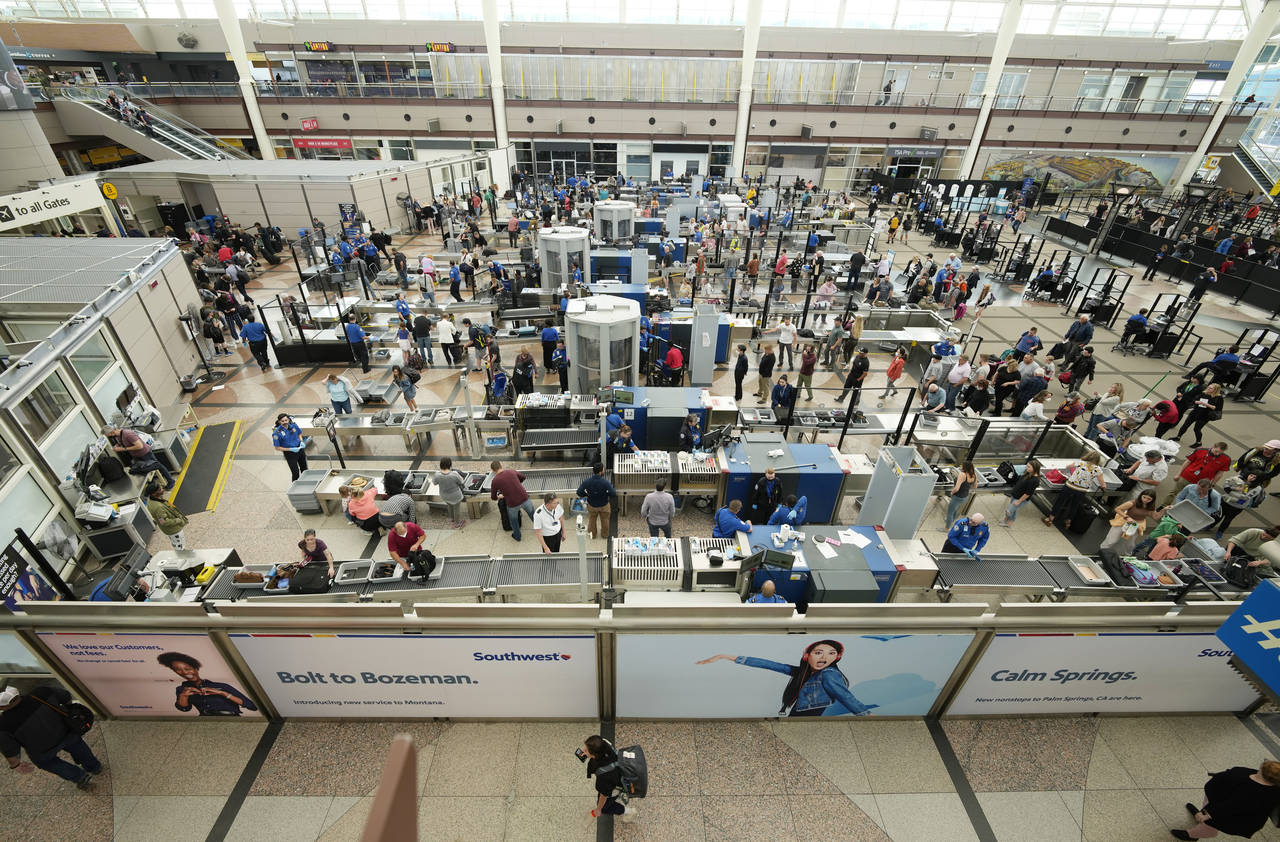 Travelers queue up at the south security checkpoint in the main terminal of Denver International Ai...