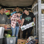 
              Gabriella Duran, far right, and local volunteers at the Mora Head Start building, help sort through food donated to families choosing to remain in Mora, N.M., on Wednesday, May 4, 2022, where firefighters have been battling the Hermit's Peak and Calf Canyon fire for weeks. Weather conditions described as potentially historic are on tap for New Mexico on Saturday, May 7, and over the next several days as the largest fire burning in the U.S. chews through more tinder-dry mountainsides. (Jim Weber/Santa Fe New Mexican via AP)
            