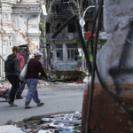 
              People walk among buildings destroyed during fighting in Mariupol, in territory under the government of the Donetsk People's Republic, eastern Ukraine, Wednesday, May 25, 2022. (AP Photo)
            