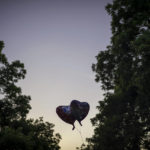 
              Two heart balloons are silhouetted against the dusk sky at a memorial site for victims of the mass shooting at Robb Elementary School in the town square of Uvalde, Texas, Friday, May 27, 2022. (AP Photo/Wong Maye-E)
            
