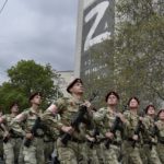 
              Russian National Guard (Rosguardia) servicemen march through a street with a letter Z, which has become a symbol of the Russian military on a building in Sevastopol, Crimea, Thursday, May 5, 2022.  (AP Photo)
            