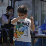 
              A child rubs his eyes after getting a COVID-19 test during a public testing on Tuesday, May 17, 2022, in Beijing. (AP Photo/Andy Wong)
            