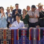 
              Utah Gov. Spencer J. Cox, left, U.S. Secretary of the Interior Deb Haaland, middle, and Jonathan Nez,  president of the Navajo Nation gather with local officials as they sign the agreement for the Navajo federal reserved water rights settlement Friday, May 27, 2022 in Monument Valley, Utah. (Rick Egan/The Salt Lake Tribune via AP)
            