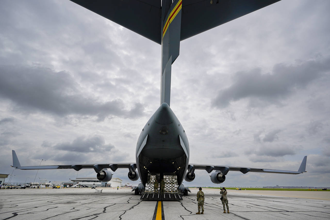 The crew of an Air Force C-17 begins to unload a plane load of baby formula at the Indianapolis Int...