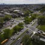 
              The Philadelphia skyline, top left, is seen at a distance as vehicular traffic flows along Roosevelt Boulevard at the intersection with North Mascher Ave, Thursday, May 12, 2022, in Philadelphia. Roosevelt Boulevard is an almost 14-mile maze of chaotic traffic patterns that passes through some of the city's most diverse neighborhoods and Census tracts with the highest poverty rates. Driving can be dangerous with cars traversing between inner and outer lanes, but biking or walking on the boulevard can be even worse with some pedestrian crossings longer than a football field and taking four light cycles to cross. (AP Photo/Julio Cortez)
            