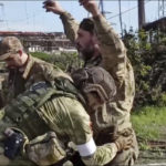 
              In this photo taken from video released by the Russian Defense Ministry Press Service on Tuesday, May 17, 2022, shows Russian servicemen frisk Ukrainian servicemen as they are being evacuated from the besieged Azovstal steel plant in Mariupol, Ukraine. More than 260 fighters, some severely wounded, were pulled from a steel plant on Monday that is the last redoubt of Ukrainian fighters in the city and transported to two towns controlled by separatists, officials on both sides said. (Russian Defense Ministry Press Service via AP)
            