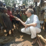 
              FILE - U.S. Ambassador Bob Krueger visits children and adults in a refugee camp in Burundi in September 1994. Krueger, who followed two U.S. House terms with a brief interim appointment to the Senate before launching a sometimes-hazardous diplomatic career, has died at age 86. A family statement to the New Braunfels Herald-Zeitung said he died Saturday, April 30, 2022 in his New Braunfels, Texas home after suffering congestive heart failure. (Judy Walgren/The Dallas Morning News via AP, File)
            