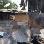 
              A man looks at the damage left from a fire that gutted houses in Quezon city, Philippines on Monday, May 2, 2022. Investigators said the fire killed several people and left more than a hundred people homeless. (AP Photo/Aaron Favila)
            