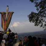
              People gather around a heavy, wooden cross before lowering it from the hilltop as part of celebrations marking the day of the Holy Cross, in the Santa Cruz Xochitpec neighborhood of Mexico City, late Monday, May 2, 2022. The importance of the fabric-draped cross is reflected in the town's very name, which means "Holy Cross of the Flowered Hill."(AP Photo/Eduardo Verdugo)
            
