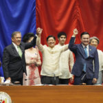 
              Philippines President-elect Ferdinand "Bongbong" Marcos Jr., center, raises hands with Senate President Miguel Zubiri, left, and House speaker Lord Allan Velasco after his proclamation by the National Board of Canvassers on Wednesday May 25, 2022 at the House of Representatives, Quezon City, Philippines. (AP Photo/Aaron Favila)
            