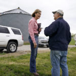 
              Iowa Gov. Kim Reynolds talks with farmer Gordon Wassenaar, right, before signing the Biofuels Bill, Tuesday, May 17, 2022, in Prairie City, Iowa. (AP Photo/Charlie Neibergall)
            
