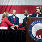
              Sen. Michelle Benson, left, shakes hands with Republican candidate for governor Kendall Qualls, as she and and Sen. Paul Gazelka, second from left, throw their support to Qualls, Saturday, May 14, 2022, at the Minnesota Republican convention in Rochester, Minn. (Glen Stubbe/Star Tribune via AP)
            