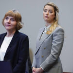 
              Actor Amber Heard stands with her attorney attorney Elaine Bredehoft in the courtroom at the Fairfax County Circuit Courthouse in Fairfax, Va., Friday, May 27, 2022. Actor Johnny Depp sued his ex-wife Amber Heard for libel in Fairfax County Circuit Court after she wrote an op-ed piece in The Washington Post in 2018 referring to herself as a "public figure representing domestic abuse." (AP Photo/Steve Helber, Pool)
            