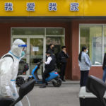 
              A worker wearing a protective suit and carrying a tank of disinfectant walks along a street in Beijing, Wednesday, May 11, 2022. Shanghai reaffirmed China's strict "zero-COVID" approach to pandemic control Wednesday, a day after the head of the World Health Organization said that was not sustainable and urged China to change strategies. (AP Photo/Mark Schiefelbein)
            