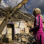 
              Iryna Martsyniuk, 50, stands next to her heavily damaged house after a Russian bombing in Velyka Kostromka village, Ukraine, Thursday, May 19, 2022. Martsyniuk and her three young children were at home when the attack occurred in the village, a few kilometres from the front lines, but they all survived unharmed. (AP Photo/Francisco Seco)
            