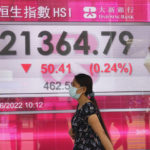 
              A woman wearing a face mask walks past a bank's electronic board showing the Hong Kong share index in Hong Kong, Wednesday, June 1, 2022. Shares were mixed in Asia on Wednesday after a wobbly day on Wall Street closed out a month buffeted by worries about a possible recession, inflation and rising interest rates. (AP Photo/Kin Cheung)
            