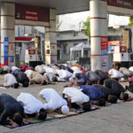 Muslim men perform Eid al-Fitr prayer marking the end of the holy fasting month of Ramadan, at a gas station outside an overflowed mosque in Jakarta, Indonesia, Monday, May 2, 2022. (AP Photo/Dita Alangkara)