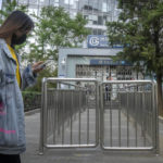 
              A commuter wearing a face mask walks past a closed subway station in the central business district in Beijing, Thursday, May 5, 2022. Hong Kong on Thursday reopened beaches and pools in a relaxation of COVID-19 restrictions, while China's capital Beijing began easing quarantine rules for arrivals from overseas. (AP Photo/Mark Schiefelbein)
            