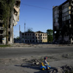 
              A boy plays in front of houses ruined by shelling in Borodyanka, Ukraine, Tuesday, May 24, 2022. (AP Photo/Natacha Pisarenko)
            