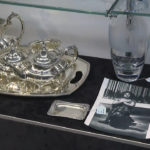
              FILE - In this image from video, a silver coffee and tea set, left, and a signed photo of an opera singer, belonging to the late Justice Ruth Bader Ginsburg, are seen inside Potomack Company Auctions in Alexandria, Va., Monday, April 11, 2022. An online auction of 150 of items owned by Ginsburg raised $803,650 for Washington National Opera. The opera was one of the late justice’s passions. (AP Photo/Nathan Ellgren, File)
            