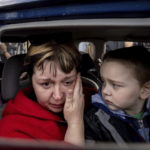 
              Natalia Pototska, 43, cries as her grandson Matviy looks on in a car at a center for displaced people in Zaporizhzhia, Ukraine, Monday, May 2, 2022. (AP Photo/Evgeniy Maloletka)
            