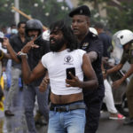 
              Sri Lankan police detain an anti-government protester during clashes in Colombo, Sri Lanka, Monday, May 9, 2022. Authorities deployed armed troops in the capital Colombo on Monday hours after government supporters attacked protesters who have been camped outside the offices of the country's president and prime minster, as trade unions began a “Week of Protests” demanding the government change and its president to step down over the country’s worst economic crisis in memory. (AP Photo/Eranga Jayawardena)
            