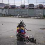 
              A backpack with the colors of the Venezuelan flag hangs on a wheelbarrow with tools near where cars are repaired on the street of the Catia neighborhood of Caracas, Venezuela, Tuesday, April 19, 2022. Mechanics are increasingly busy as they try to coax a little more life out of aging vehicles in a country whose new car market collapsed and where few can afford to trade up for a better used one. (AP Photo/Matias Delacroix)
            