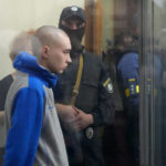 
              Russian army Sergeant Vadim Shishimarin, 21, is seen behind a glass during a court hearing in Kyiv, Ukraine, Friday, May 13, 2022. The trial of a Russian soldier accused of killing a Ukrainian civilian opened Friday, the first war crimes trial since Moscow's invasion of its neighbor. (AP Photo/Efrem Lukatsky)
            