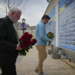 
              Ukrainian Foreign Minister Dmytro Kuleba, right, and Vatican Secretary for Relations with States Archbishop Paul Richard Gallagher lay flowers at the Memorial Wall of Fallen Defenders of Ukraine in Russian-Ukrainian War in Kyiv, Ukraine, Friday, May 20, 2022. (AP Photo/Efrem Lukatsky)
            