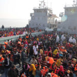 
              FILE - Rohingya refugees wait on naval ships to be transported to an isolated island in the Bay of Bengal, in Chittagong, Bangladesh, on Dec. 29, 2020. The number of people forced to flee conflict, violence, human rights violations and persecution has crossed the milestone of 100 million for the first time on record, propelled by the war in Ukraine and other deadly conflicts, The U.N. refugee agency said Monday, May 23, 2022.  (AP Photo/Mahmud Hossain Opu, File)
            