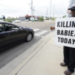 
              Longtime anti-abortion activist E.C. Smith, of Canton, Miss., acknowledges a positive comment as he walks alongside the Jackson Women's Health Organization (JWHO), Mississippi's last remaining abortion clinic, called the "Pinkhouse", Tuesday, May 3, 2022, in Jackson, Miss. (AP Photo/Rogelio V. Solis)
            