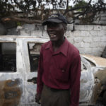 
              Jean Claude Celestin recalls how his car was set on fire during clashes between armed gangs in the Butte Boyer neighborhood of Port-au-Prince, Haiti, Friday, May 13, 2022. Gangs are fighting each other and seizing territory in the capital of Port-au-Prince with a new intensity and brutality in a country that many feel is swiftly unraveling as it tries to recover from the July 7 assassination of President Jovenel Moïse. (AP Photo/Odelyn Joseph)
            