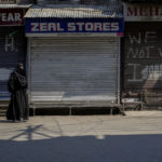 
              A woman walks past closed shops painted with graffiti in Srinagar, Indian controlled Kashmir, Thursday, May 26, 2022. Police in disputed Kashmir arrested at least 10 youths during overnight raids following an anti-India protest that erupted as an Indian court sentenced a prominent Kashmiri pro-independence leader to life in prison, officials said Thursday. (AP Photo/Mukhtar Khan)
            