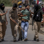 
              Policemen detain a Kashmiri Hindu, locally known as Pandits, during a protest march against the killing of Rahul Bhat, also a Pandit, on the outskirts of Srinagar, Indian controlled Kashmir, Friday, May 13, 2022. Hindus in Indian-controlled Kashmir staged protests on Friday a day after assailants shot and killed the government employee from the minority community. It was the first time that Pandits, an estimated 200,000 of whom fled Kashmir after an anti-India rebellion erupted in 1989, simultaneously organized street protests at several places in the Muslim-majority region. (AP Photo/Dar Yasin)
            
