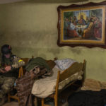 
              A Ukrainian National Guard soldier takes a break in a house used as temporary base in a recently retaken village on the outskirts of Kharkiv, east Ukraine, Saturday, May 14, 2022. (AP Photo/Bernat Armangue)
            